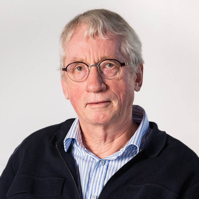 an older man wearing glasses and a jacket.